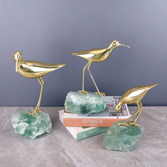 The Serene Shore bird displayed on a bookshelf, adding a touch of artistic charm and natural energy to a modern room.