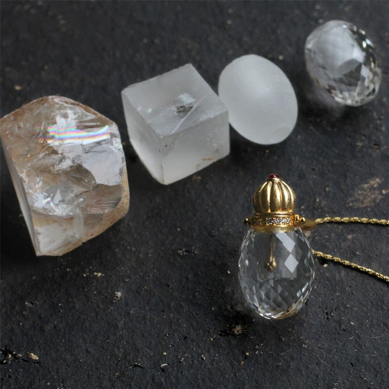 Showing the clear quartz perfume vial alongside its Authenticity Certificate, ensuring high-quality natural material.