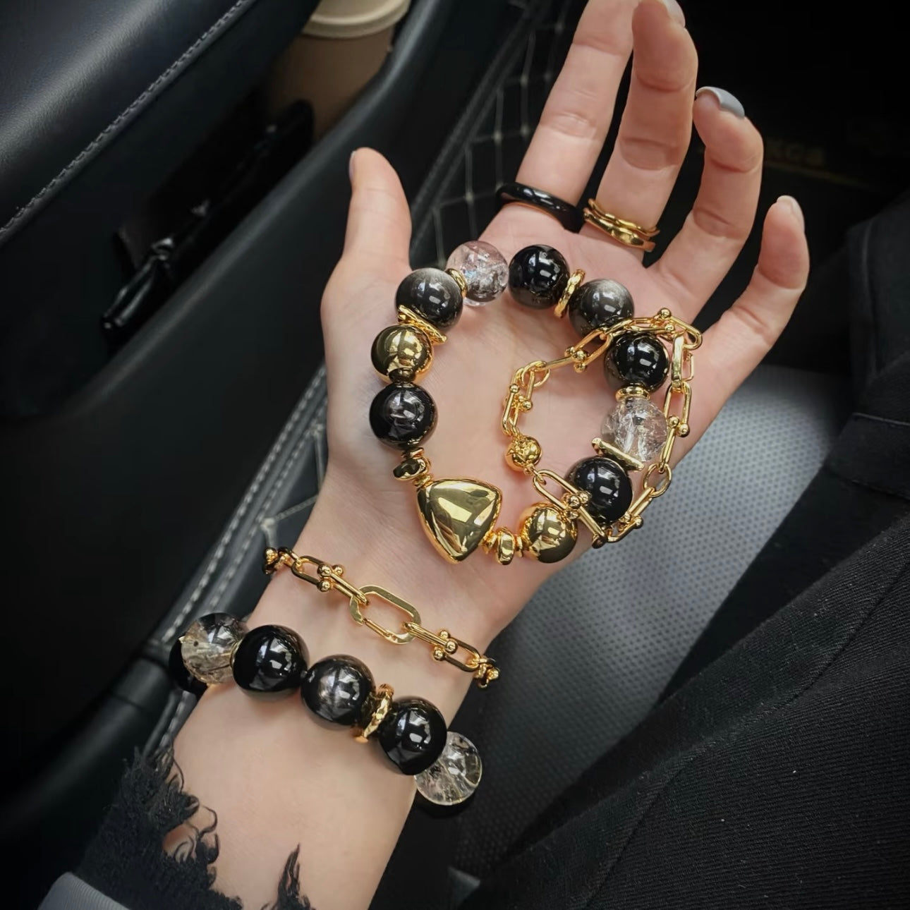 Lifestyle shot of black agate crystal bracelet and gold chain bracelet gift set worn together, bold aura styling for women who love meaningful jewelry