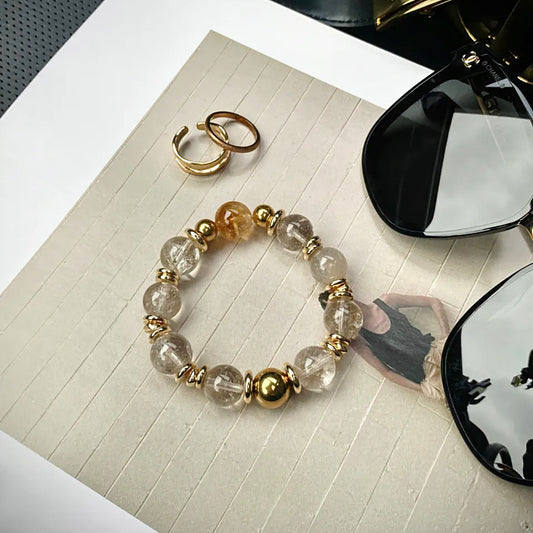 Natural Citrine Tower Crystal bracelet featuring Smoky White Azeztulite and 24K gold-plated titanium steel hardware displayed in a minimalist flat lay.