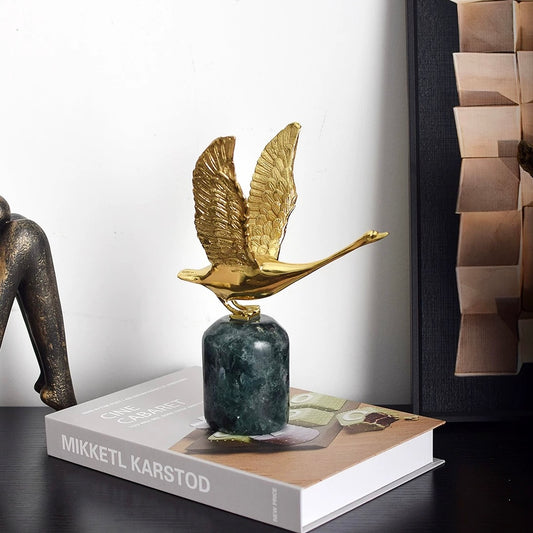Side profile of the brass swan ornament, highlighting the elegant neck curvature and the dynamic upward movement.