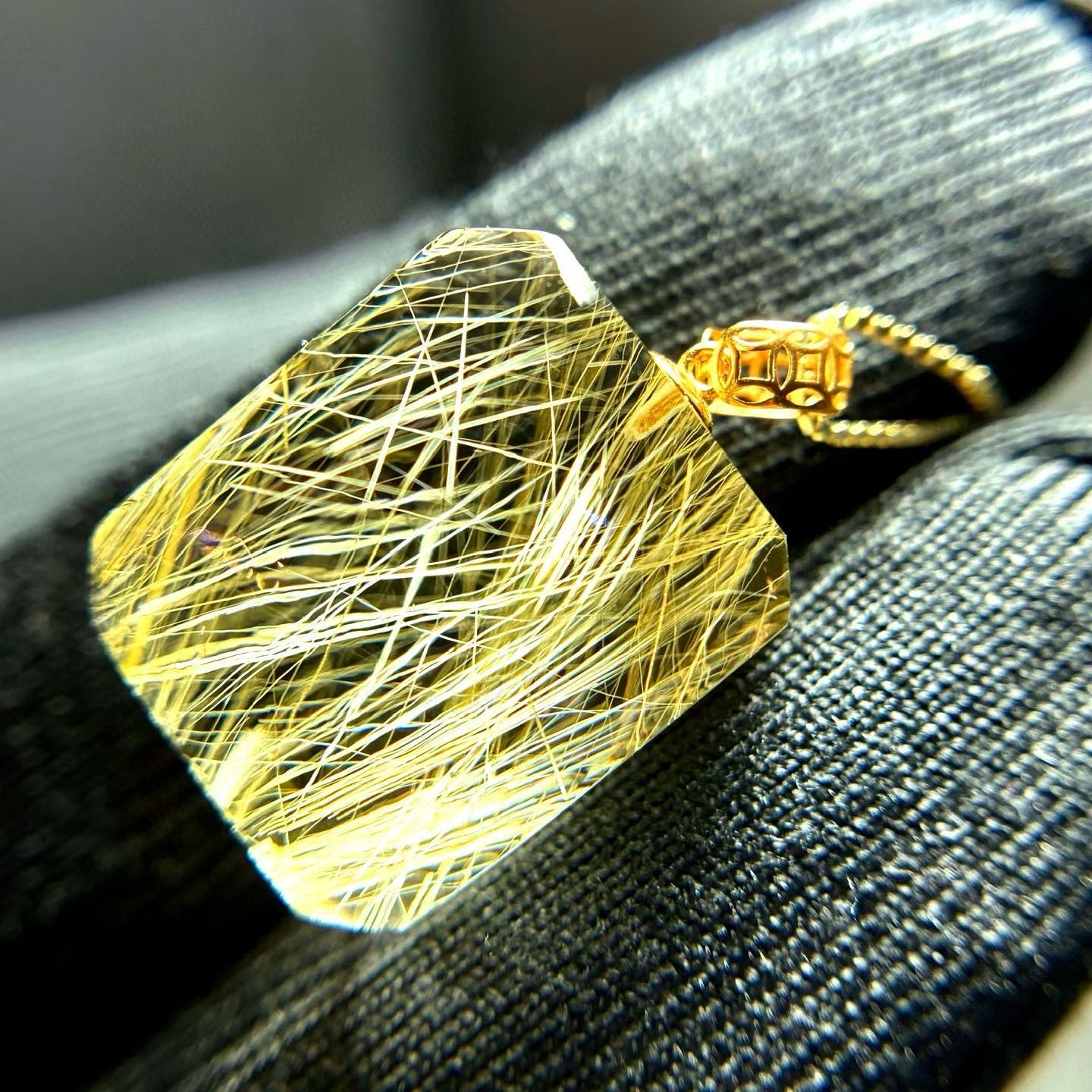 The golden rutilated quartz pendant styled as a collector's item, emphasizing its heirloom value.