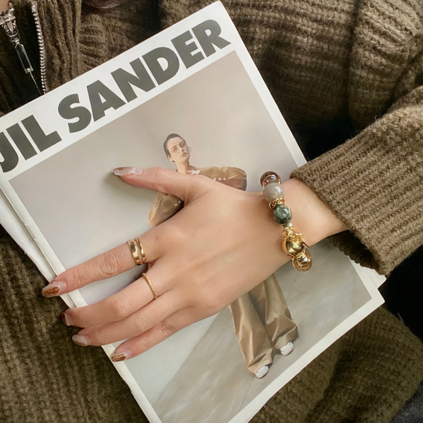 A curated flatlay featuring the high-fashion green dragon and phantom quartz bracelet.