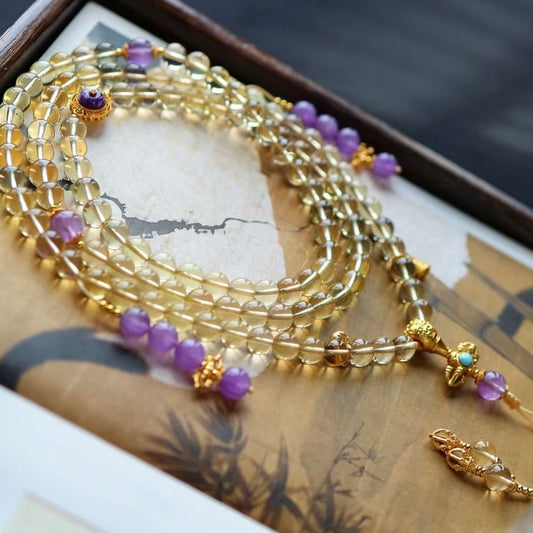 Macro shot showing the detail of purple mica, gold-plated silver, and clear citrine beads.
