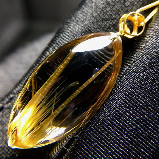 Side perspective of the 5.1g titanium quartz showing the precision of the marquise cut and gold inlay.