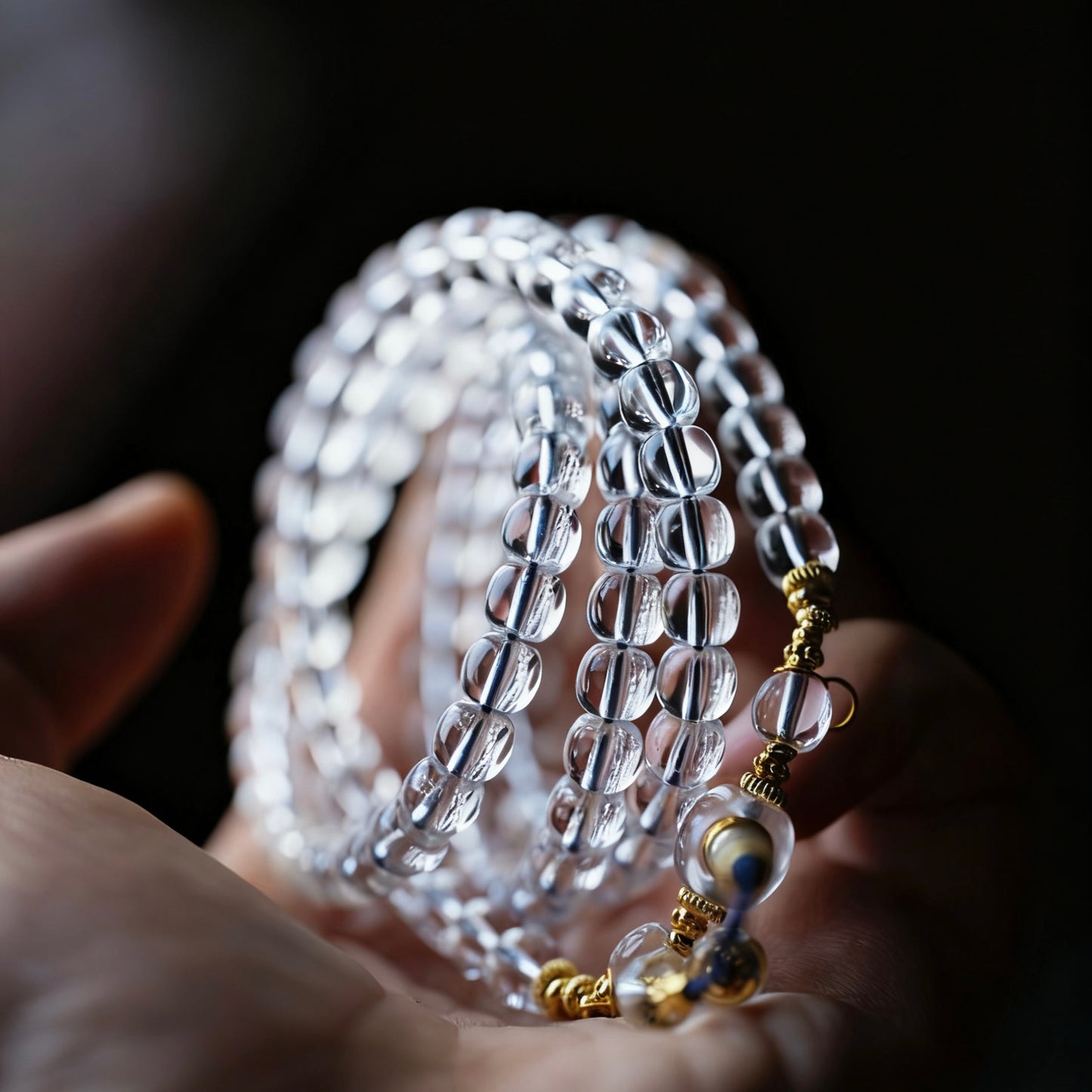 Hands in prayer position with the crystal mala wrapped around, embodying Zen luxury.