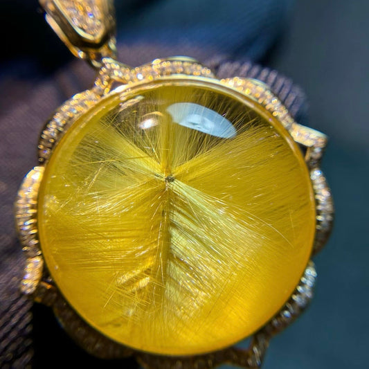 The exact 1 of 1 18K gold sunburst rutilated quartz flower pendant with rare star-center needles.