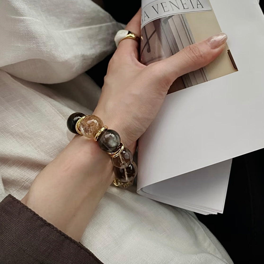 Layered crystal bracelet styling with vintage smoky quartz and 24K gold PVD hardware on wrist