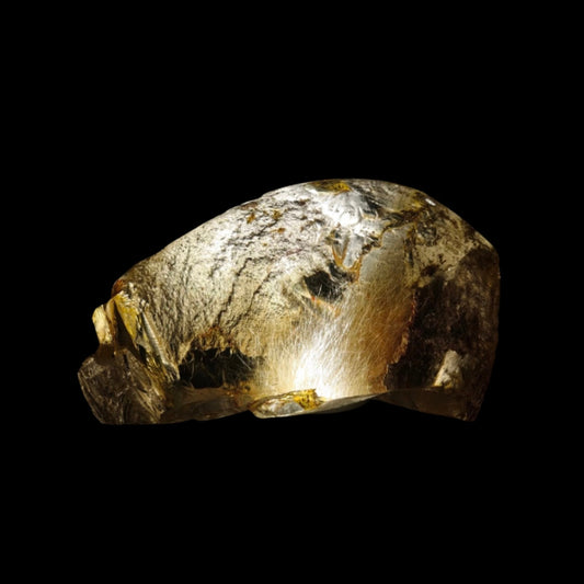 High-intensity spotlight penetrating the mineral rind of a raw Brazilian Titanium Crystal to reveal internal rutiles.