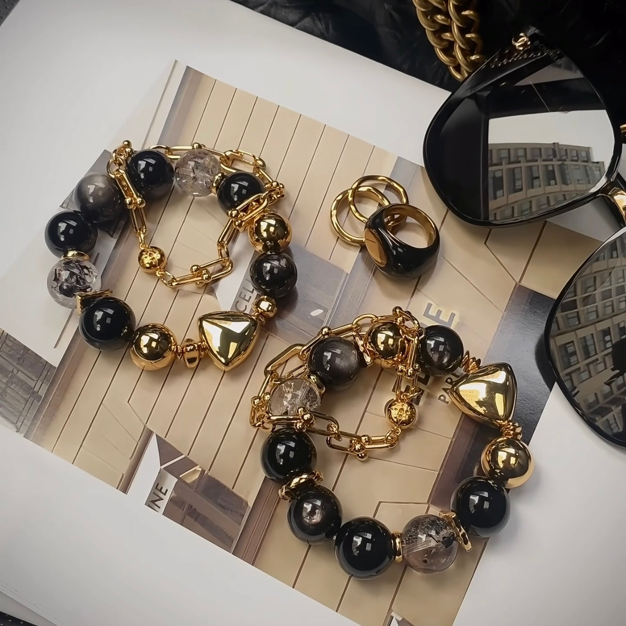 Close-up of 14mm black warrior sparkle diamond and silver obsidian beads alongside vacuum ion-plated 24K gold titanium steel bracelet, fade-resistant finish