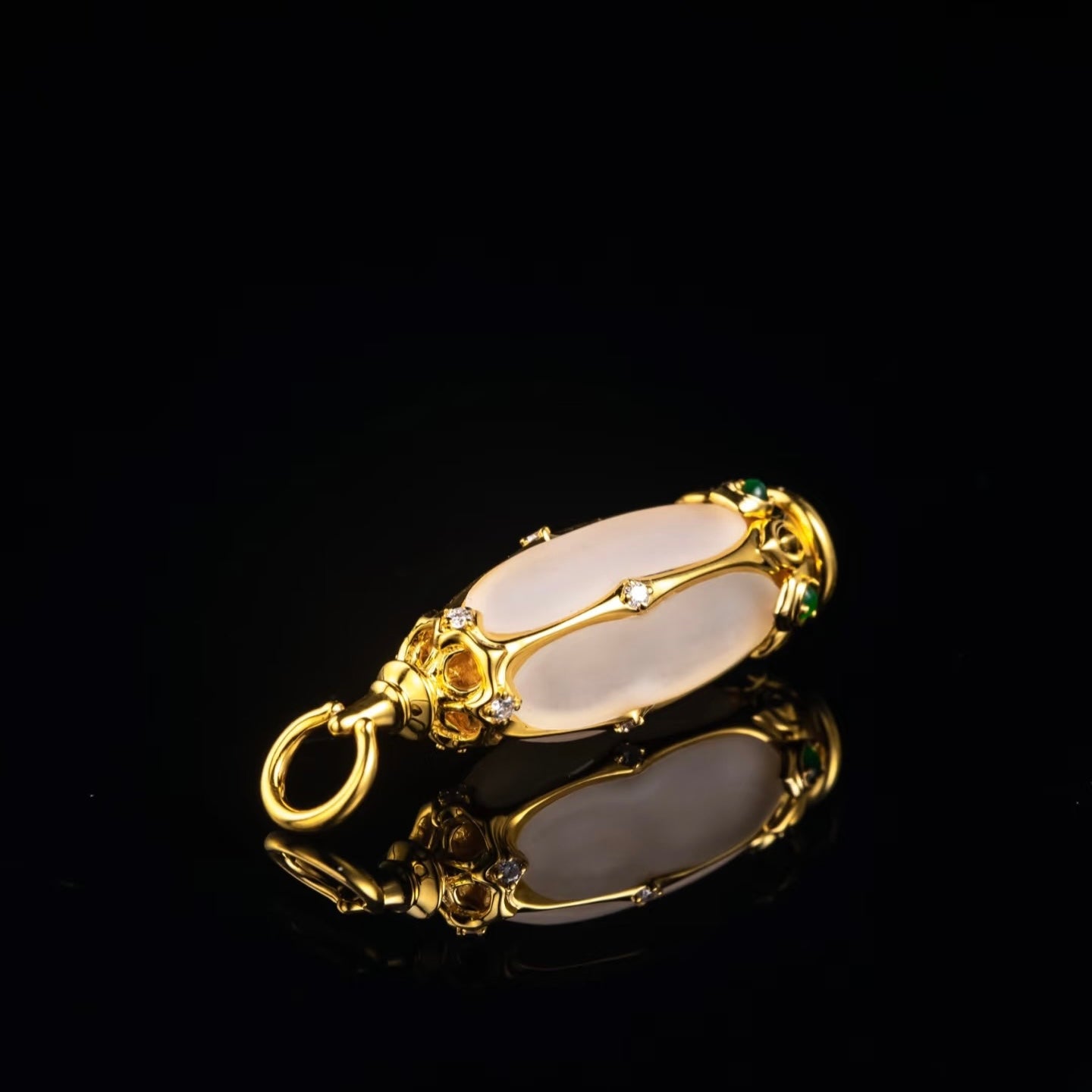 Close-up of 18K gold Buddhist pendant showing diamond and tourmaline embellishments on shrine frame