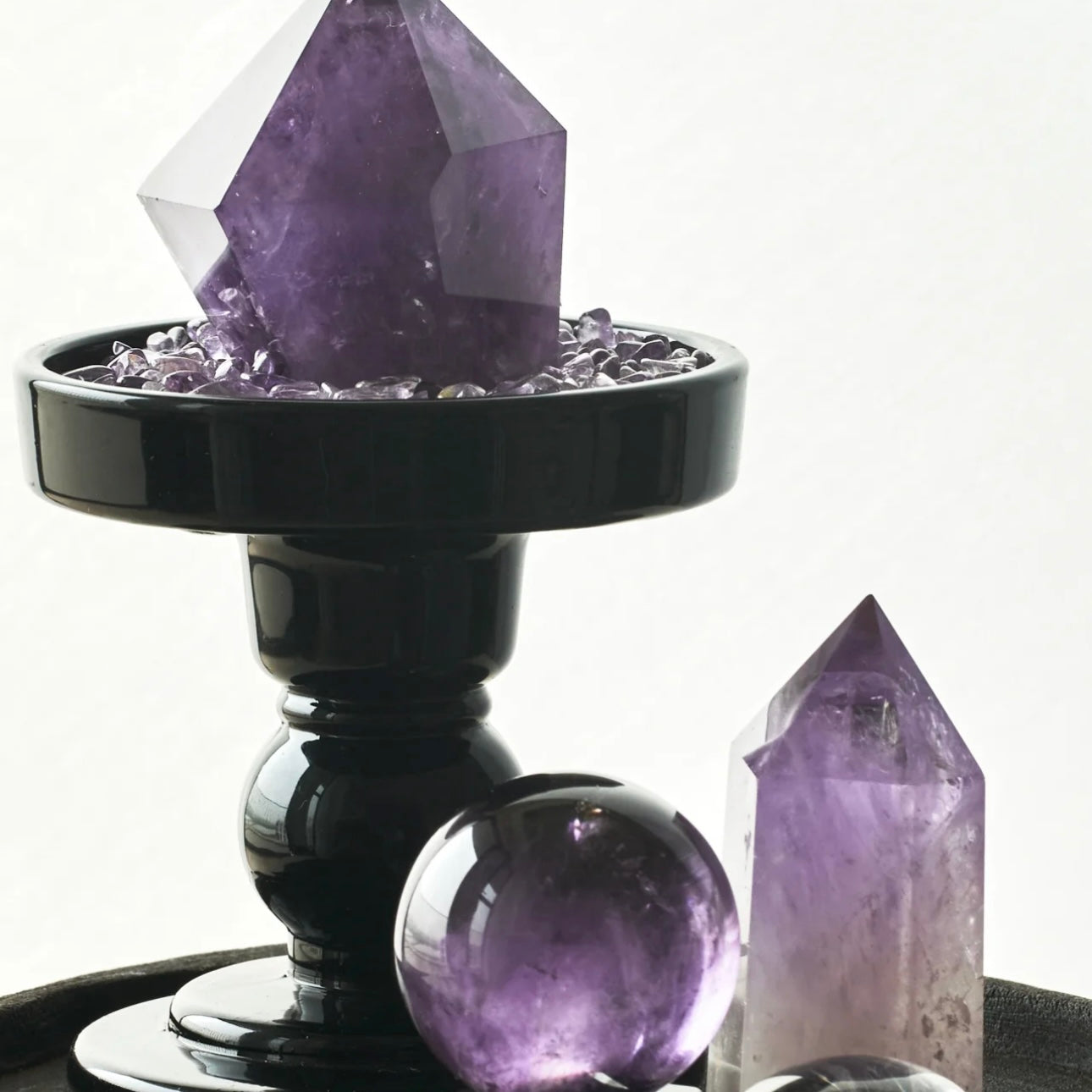 A hand holding an amethyst sphere, illustrating its smooth finish and random natural shapes that radiate purification.
