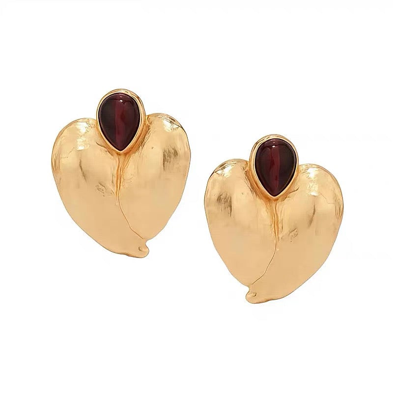 Front view of the abstract heart-shaped gold studs, showcasing the avant-garde silhouette.