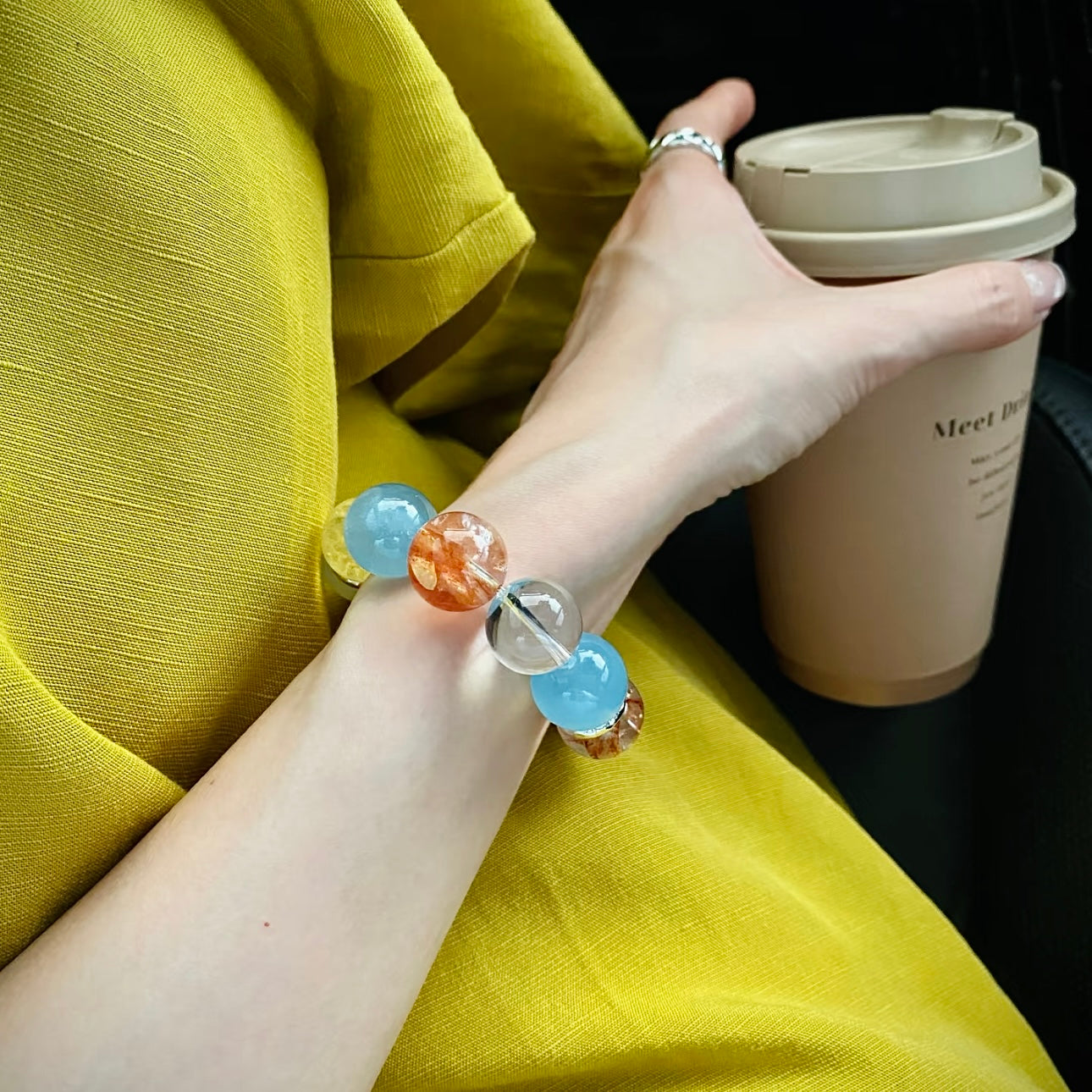 Lifestyle shot of candy-colored crystal bracelet with flower agate and citrine beads worn at beach, vibrant summer jewelry gift for women