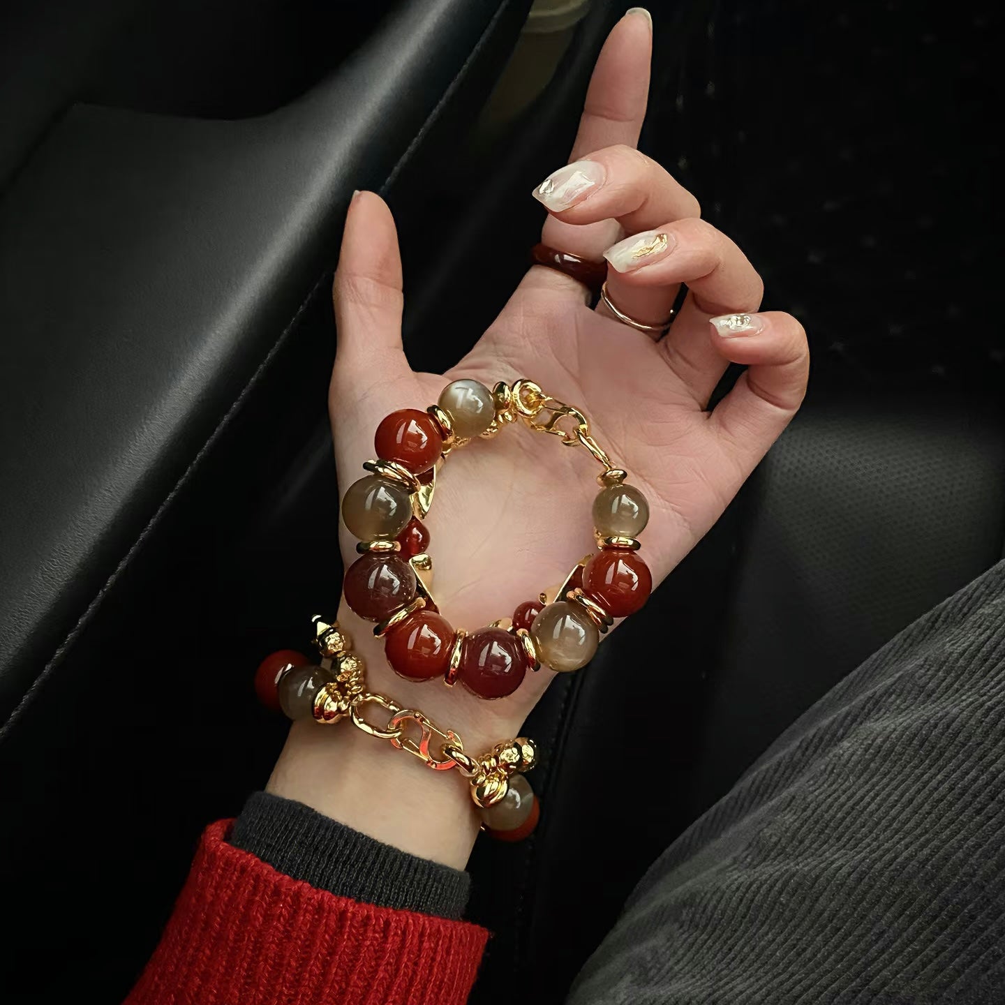 Model wearing a 15mm carnelian bead bracelet with 24K gold-plated chunky chain accessories.