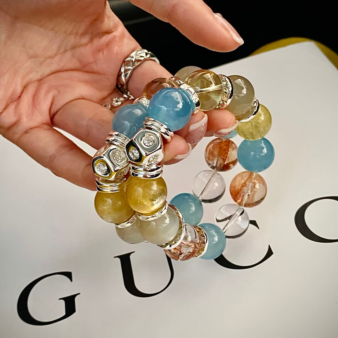 Model showcasing stacked candy-colored gemstone bracelets with champagne moonstone and golden lepidolite beads, summer crystal jewelry styling