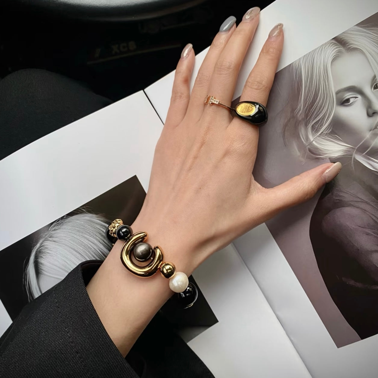 ECLIPSE bracelet styled with layered jewelry look, featuring Silver Obsidian and Freshwater Pearl against minimalist outfit