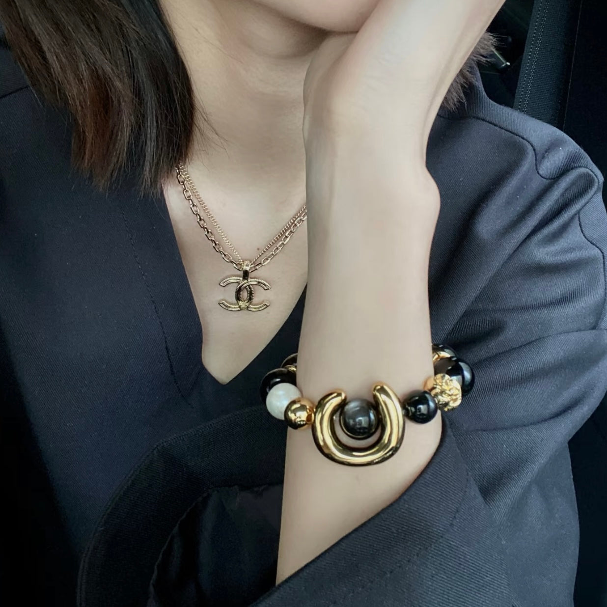Side angle view of ECLIPSE multi-stone bracelet on model, highlighting metallic sheen of Silver Obsidian and soft luminosity of Freshwater Pearl