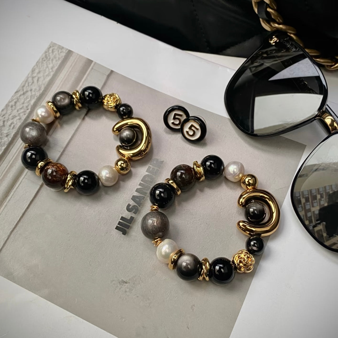 Close-up detail of ECLIPSE bracelet showing Silver Obsidian mirror sheen, Starlight Astrophyllite and Black Agate beads on 24K gold titanium clasp