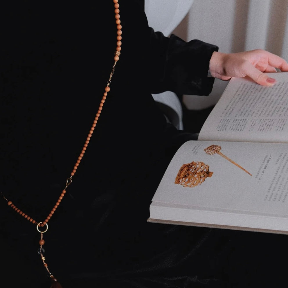 Model holding the Zen necklace in its packaging, ideal for conveying sincere wishes as an elegant and meaningful gift.