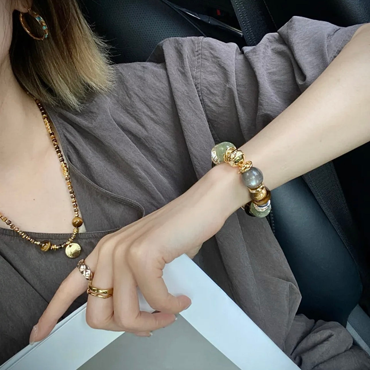 Hand model wearing natural stone chunky bracelet paired with linen outfit and gold accessories — old money aesthetic jewellery styling by Gentle Crystals