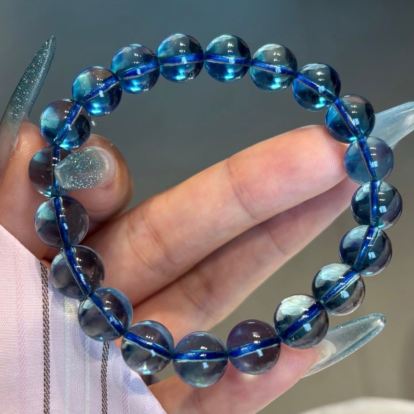 An extreme macro shot focusing on the internal growth lines and subtle variations (earth DNA) of a flawless 10.2mm natural aquamarine bead, proving its Top 1% Grade authenticity.