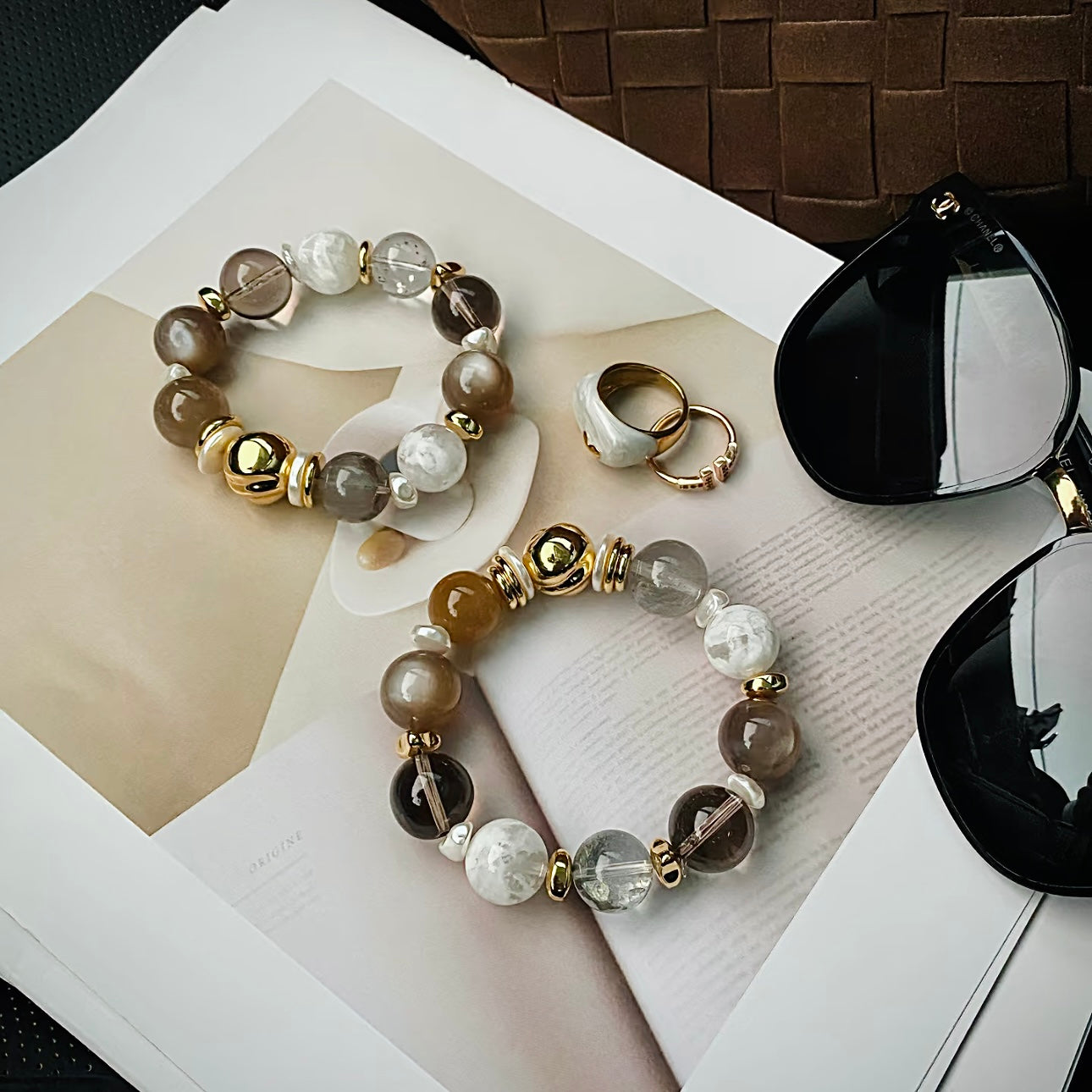 Close-up of 14-15mm white snowflake phantom quartz beads with rare internal inclusions, mother-of-pearl discs and 24K gold titanium steel findings