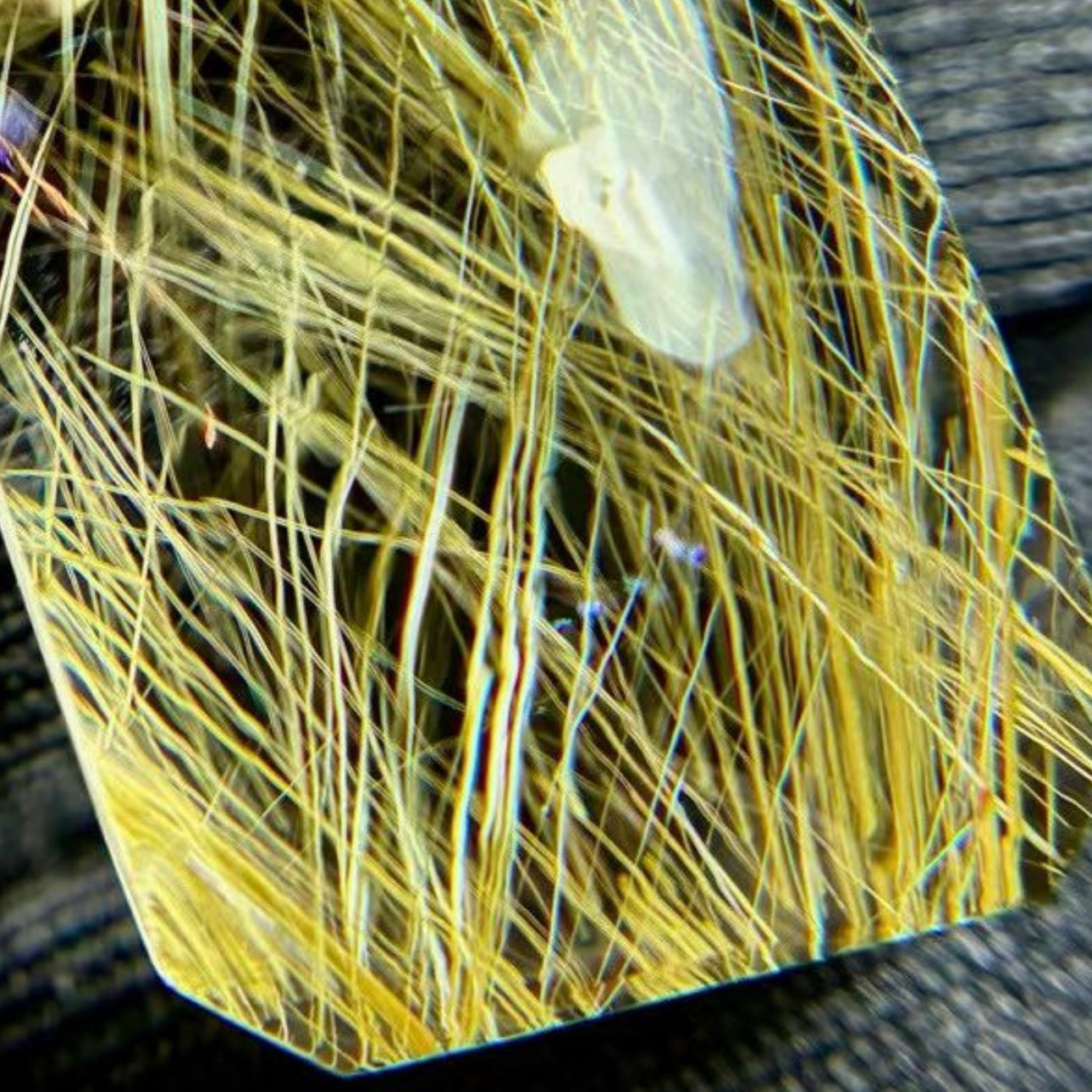 Side view of the square cut rutilated quartz showing its 9.7mm thickness and geometric precision.