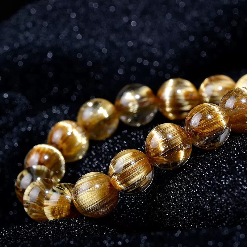 Close-up of Golden Rutilated Quartz bracelet showing golden needle inclusions inside crystal beads