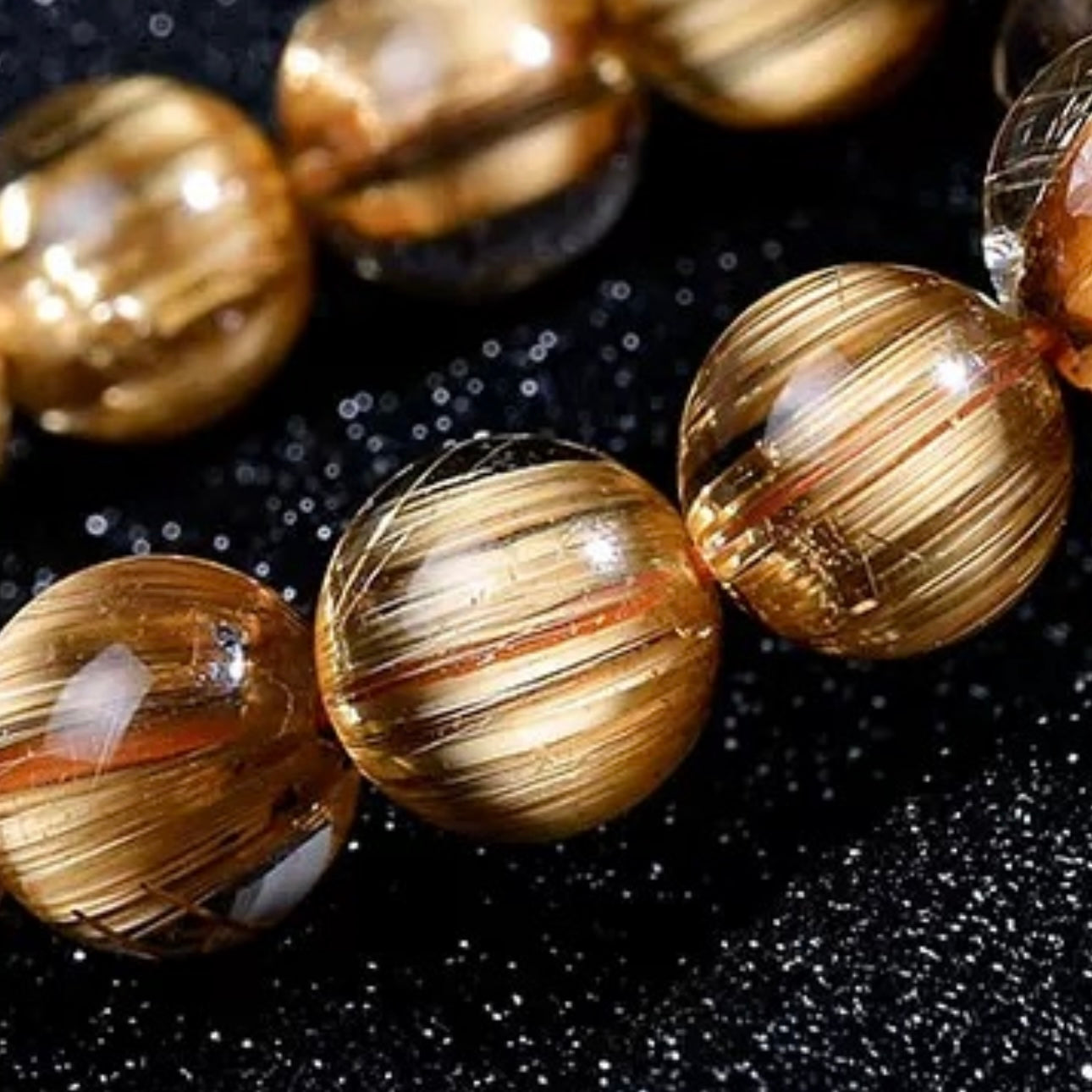 Golden Rutilated Quartz bracelet styled with other crystal jewelry pieces on neutral background