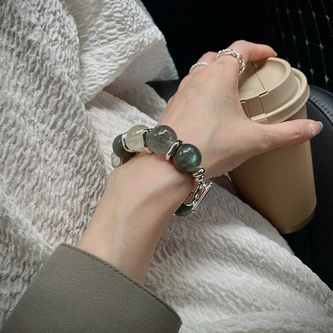 Hand model wearing a Green Rutile and Moonstone crystal bracelet styled for everyday jewelry and contemporary minimalist fashion.