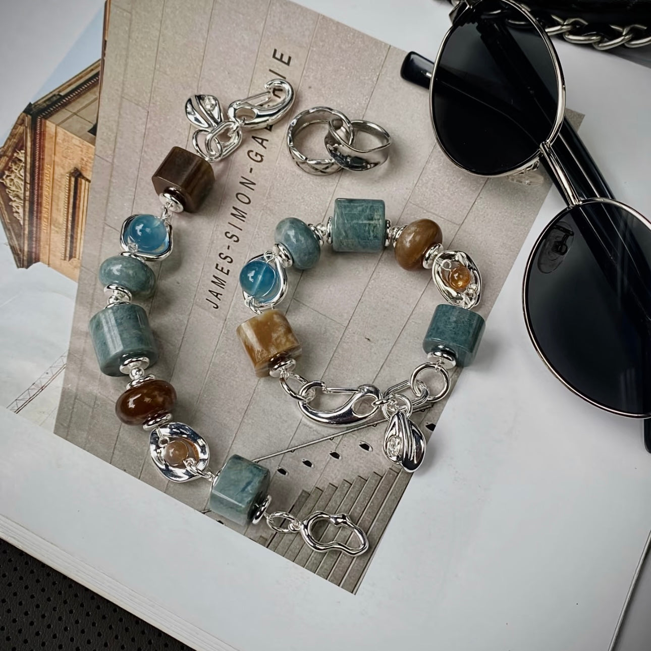 Hetian jade and aquamarine bracelet in blue and brown contrast palette, flat lay on neutral surface — 14–15mm natural stone beads with 999 silver-plated titanium hardware