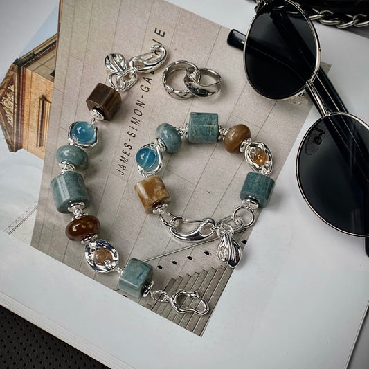 Hetian jade and aquamarine bracelet in blue and brown contrast palette, flat lay on neutral surface — 14–15mm natural stone beads with 999 silver-plated titanium hardware