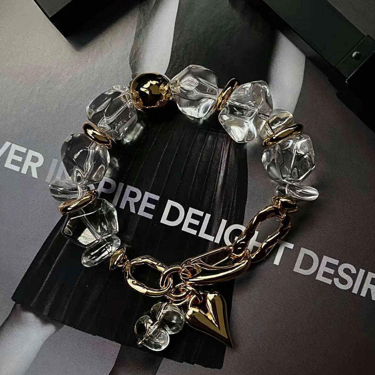 High-fashion model wearing the industrial-style crystal and gold statement bracelet.