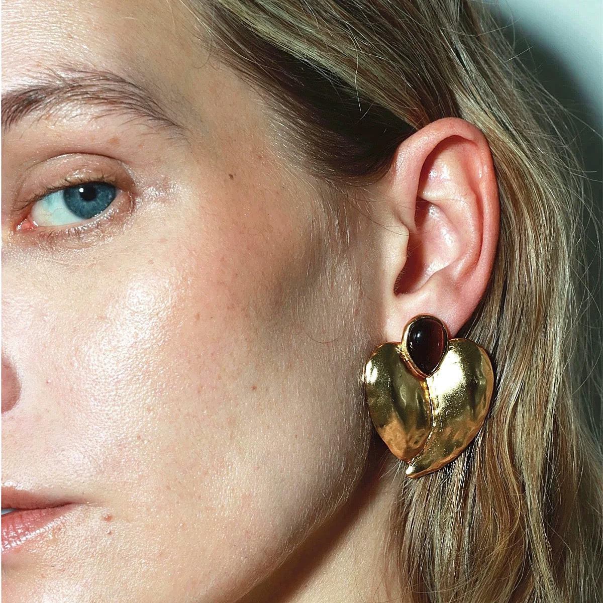 Close-up of the organic, handcrafted gold-plated texture and the deep-toned center accent.
