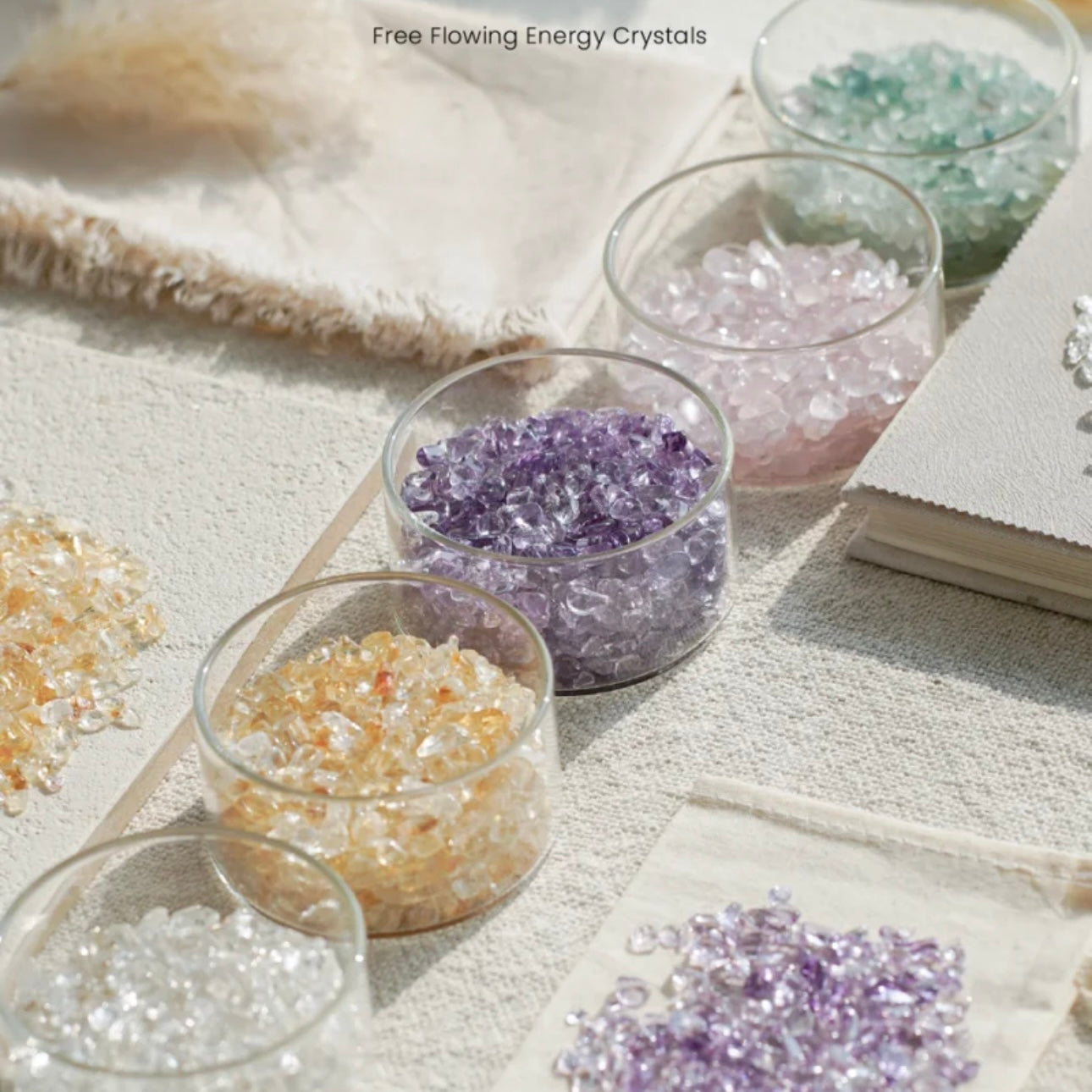 A collection of 12 varieties of natural crystal energy chips in minimalist glass vessels for meditation.