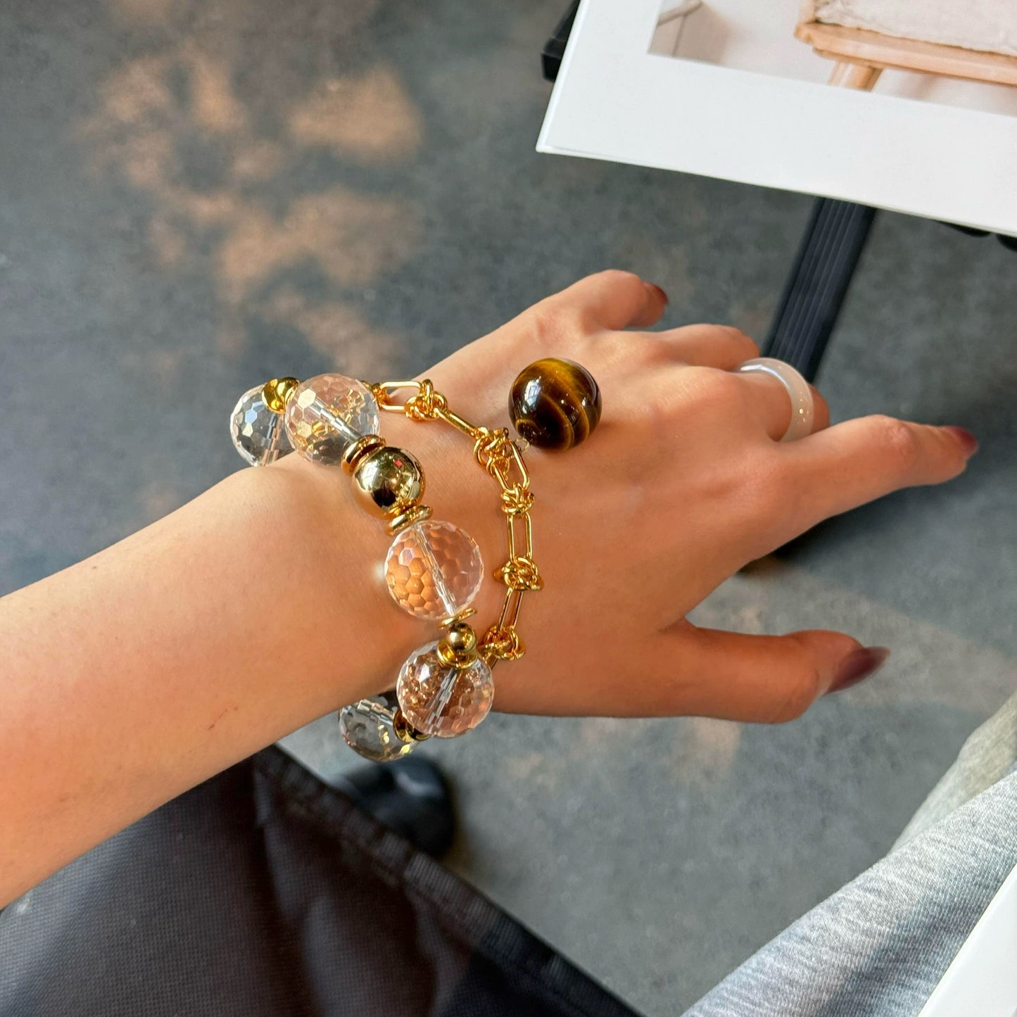 A luxury 15mm faceted white crystal bracelet featuring 24K gold-plated accessories on a wrist.