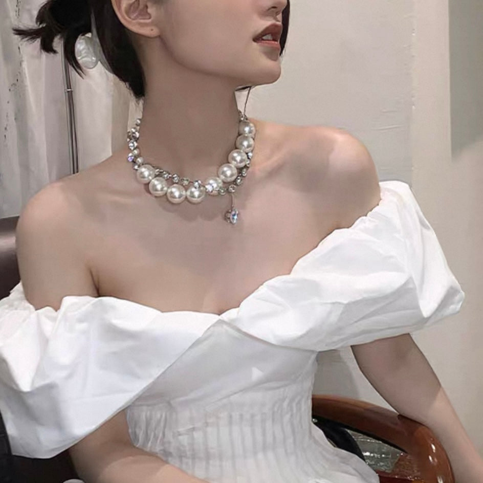 Holding the 28mm pearls to demonstrate their impressive size and substantial fashion presence.