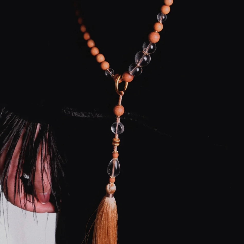 Model using the Clear Quartz and Sandalwood beads for meditation, illustrating soul calming and mental healing.