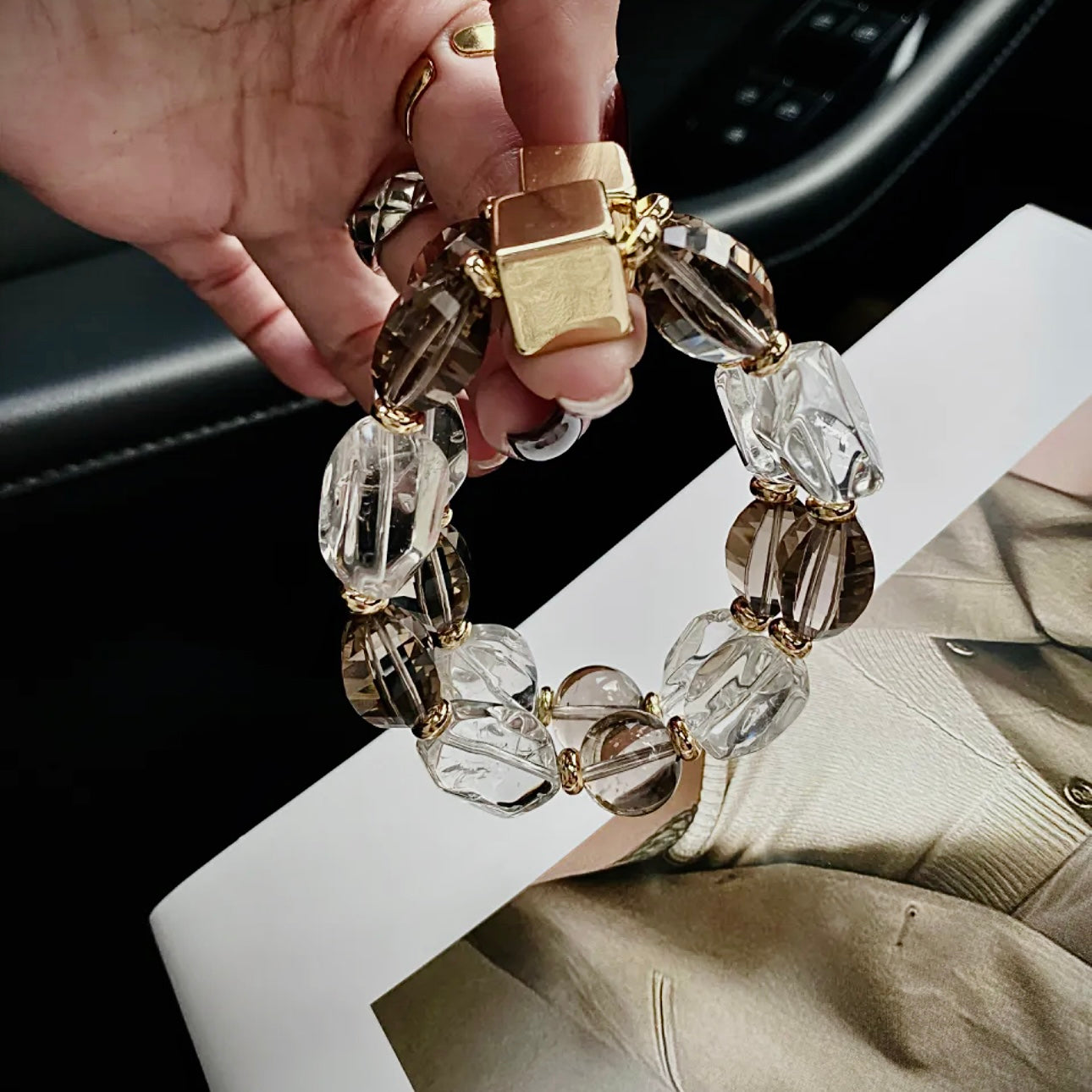 Close-up of a hand wearing a Smoky Quartz and Clear Quartz bracelet, highlighting natural gemstone textures and minimalist jewelry design.