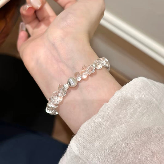 Woman wearing a white freeform clear quartz bracelet on its own, creating a clean minimalist jewelry look for everyday styling.