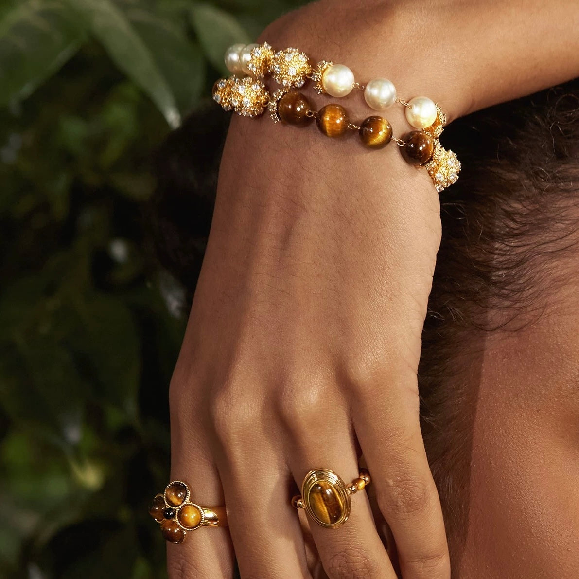 Close-up of a model's hands interacting with the high-quality gold accessories.