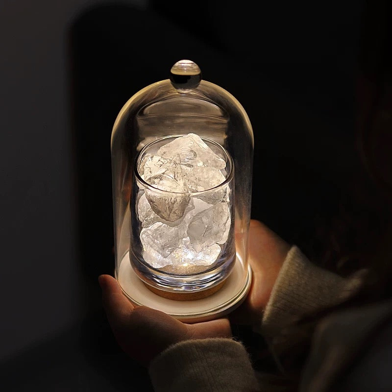 Model holding a glowing blue crystal diffuser lamp with a glass cloche, showcasing its calming effect.