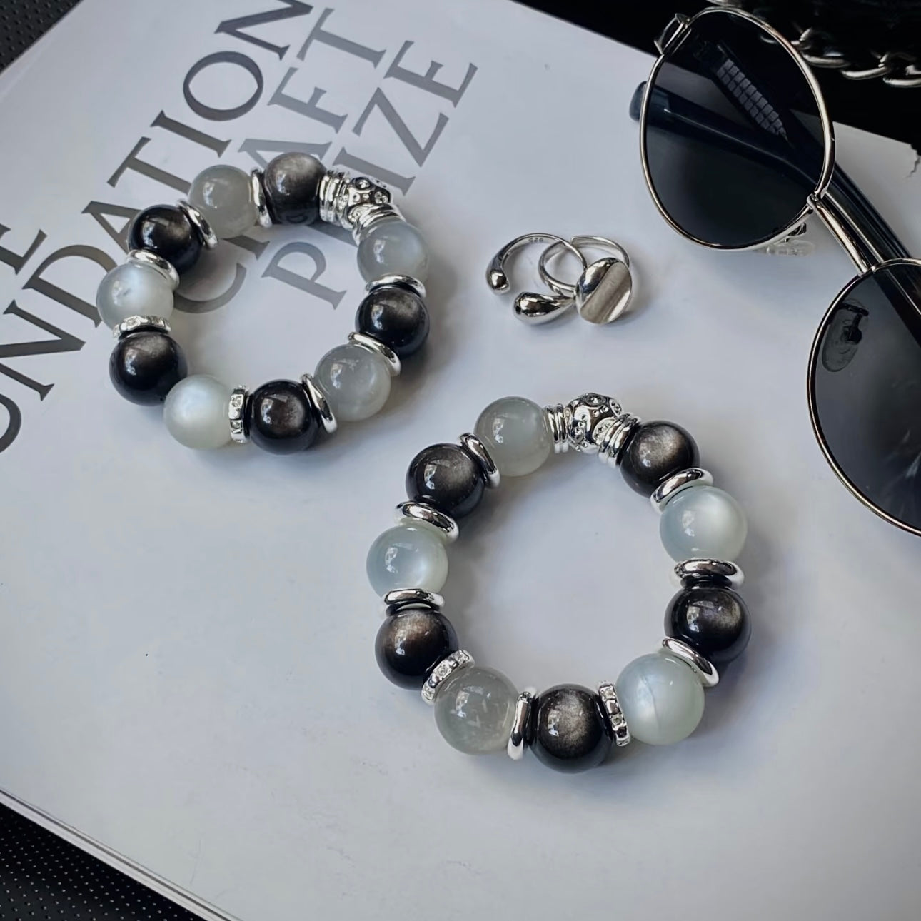 Natural Silver White Moonstone and Silver Obsidian bracelet displayed in a minimalist flat lay for everyday wear and modern crystal jewelry styling.