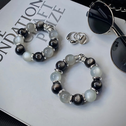 Natural Silver White Moonstone and Silver Obsidian bracelet displayed in a minimalist flat lay for everyday wear and modern crystal jewelry styling.