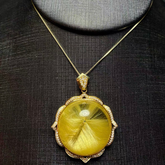 The unique rutilated quartz mandala pendant styled as a high-value collector's treasure.