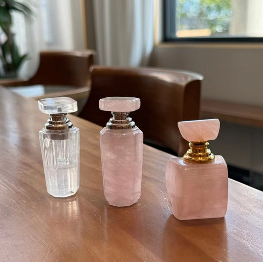 A close-up of hands opening a rose quartz gemstone bottle to reveal the apothecary interior.