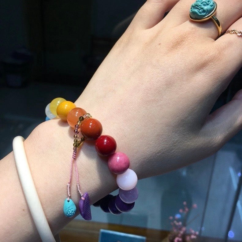 The vibrant rainbow energy bracelet styled in a serene, high-end lifestyle setting.