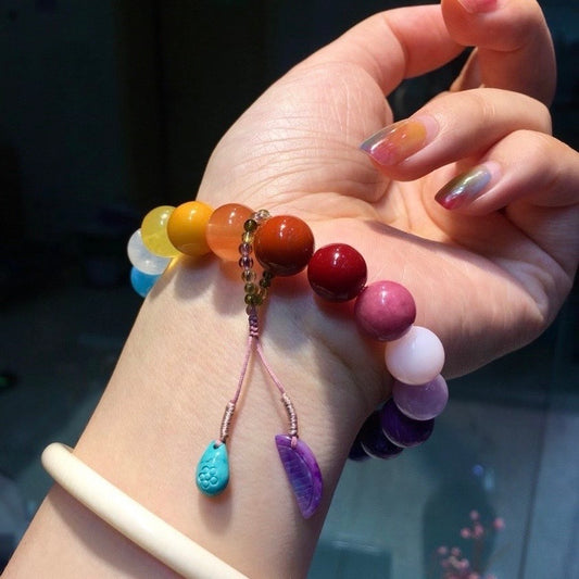 Close-up of rare sugilite beads and a delicate tourmaline tassel on a natural gemstone bracelet.