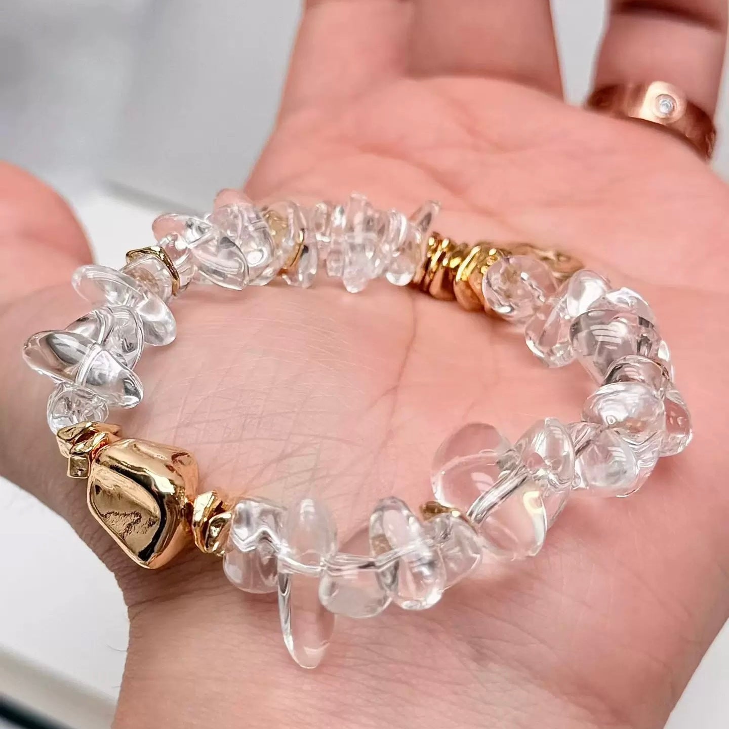 Natural clear quartz beads showing unique organic shapes and shimmering light refraction.